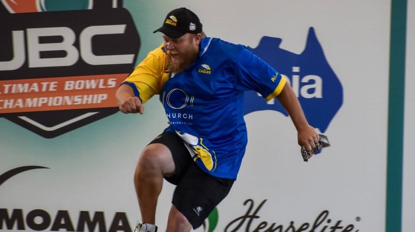 Eagles player leaping in celebration in front of the sponsor banners at Moama Bowling Club during Ultimate Week December 2022